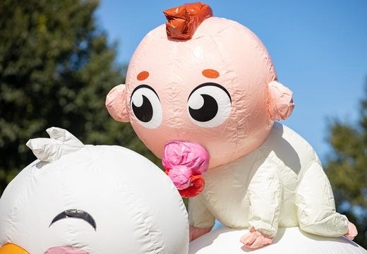 Zum Verkauf stehende 3D-Puppe eines Babys mit rosa Schnuller auf einem Storch
